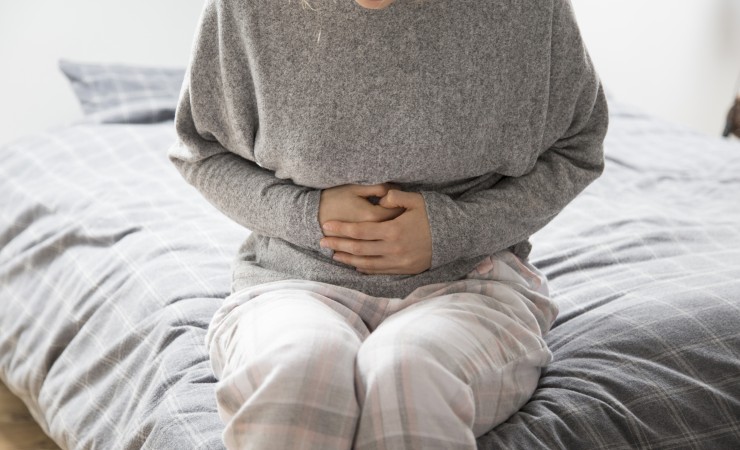 small sick woman with hands stomach suffering from intense pain